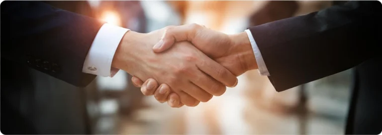 Case Studies Business professionals shaking hands in a partnership meeting